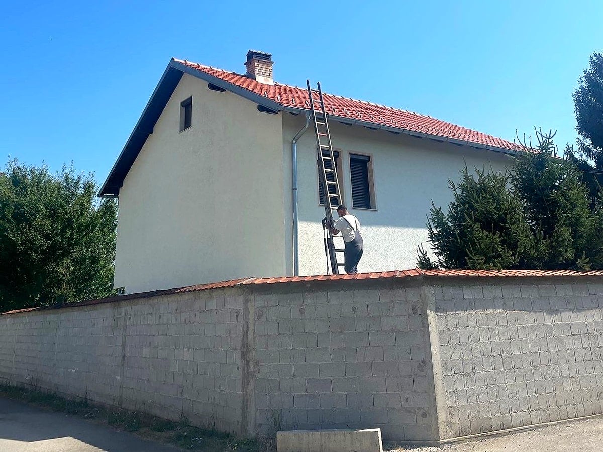 Punëtor në shkallë gjatë pastrimit të fasadës